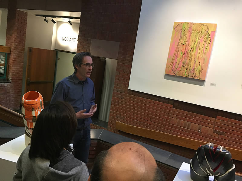 Joe Fucigna, Coordinator of Fine Arts and Studio Arts programs, discussing his painting