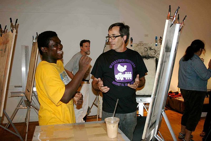 Pierre Antoine, left, a Norwalk High student, listens as Professor Joe Fucigna, right, explains the basics of sketching.